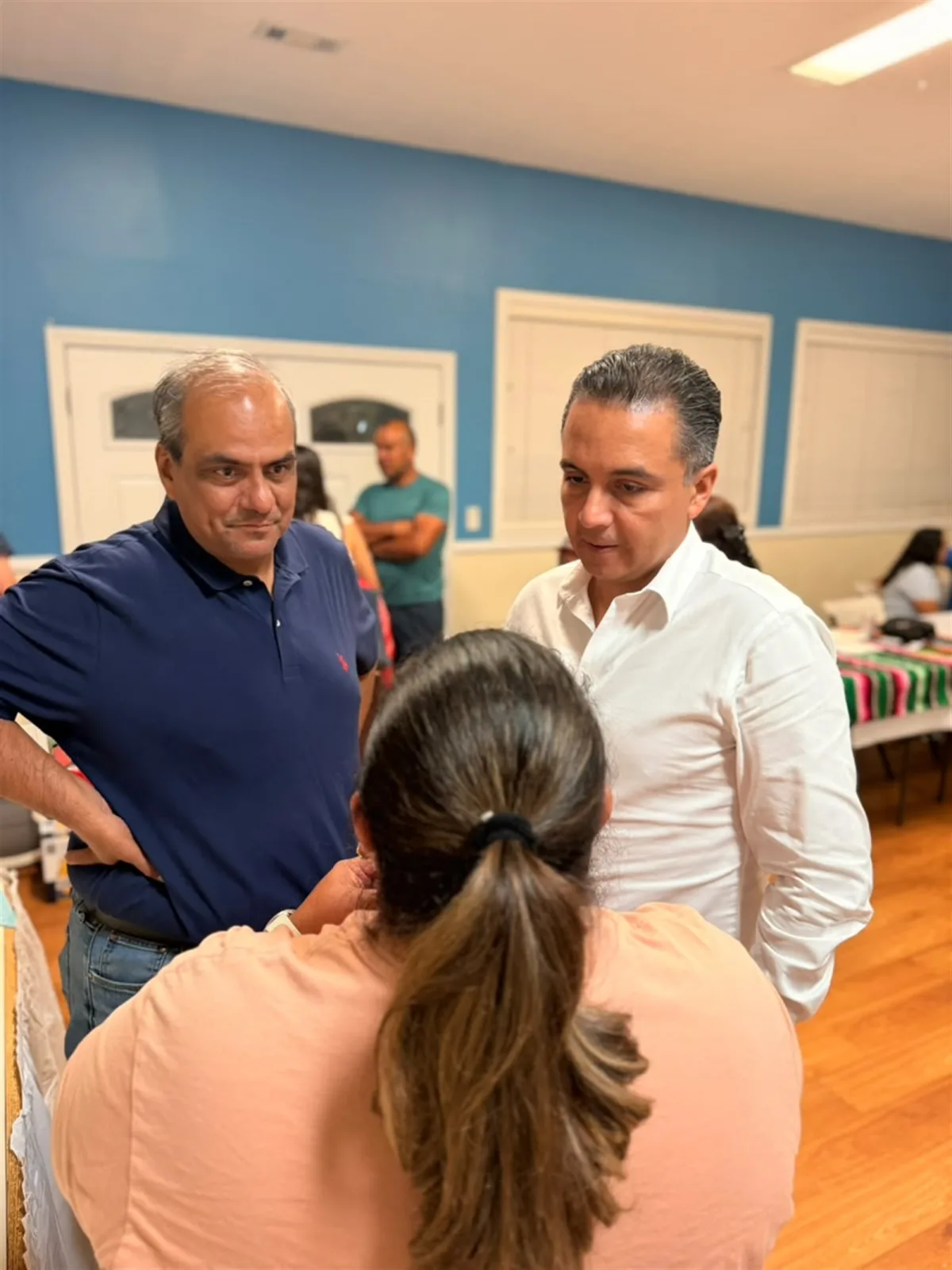 Eric Gudiño Torres y Luis Bernardo González Zepeda conversan con una integrante de la comunidad migrante queretana durante una reunión en Hillsborough, Nueva Jersey.